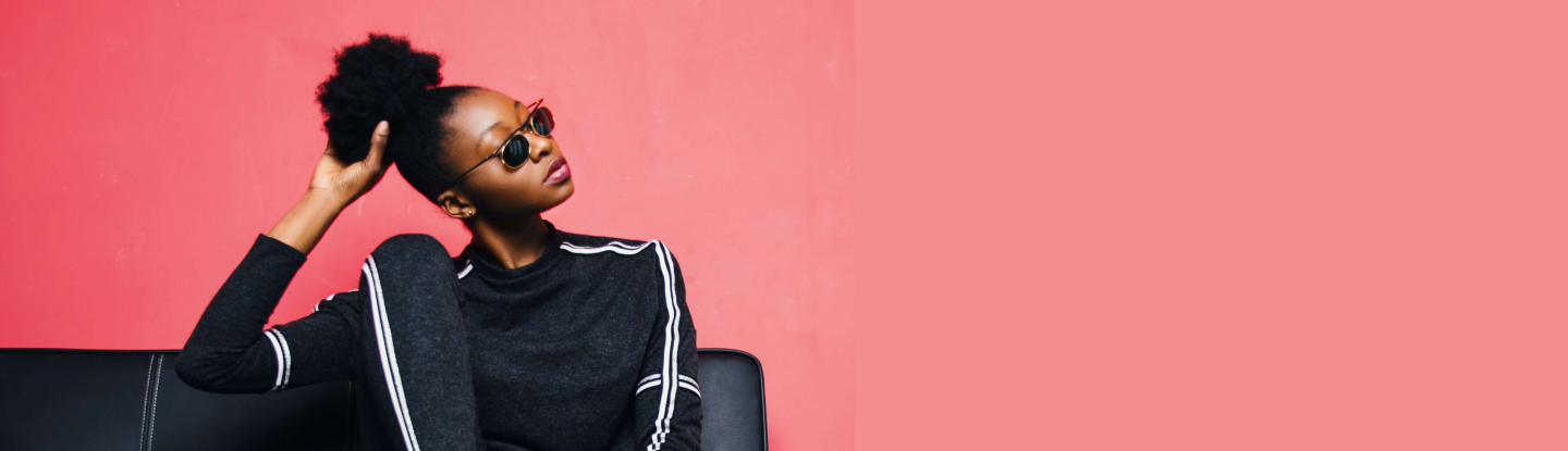 Modelo femenina vistiendo una blusa negra, en fondo rosa
