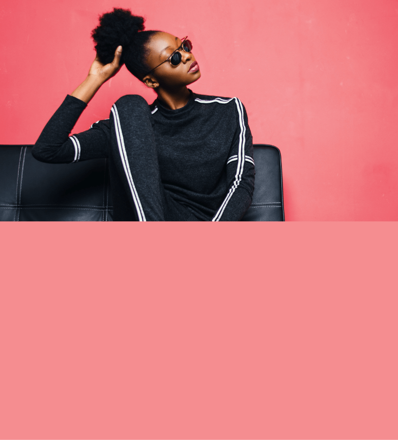 Modelo femenina vistiendo una blusa negra, en fondo rosa
