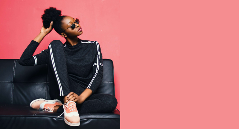 Modelo femenina vistiendo una blusa negra, en fondo rosa