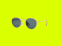 Gafas de sol con lentes redondeadas y montura dorada, en fondo verde limón